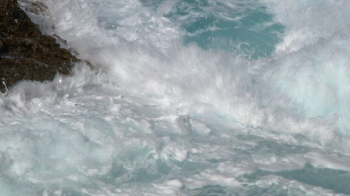 Foamy sea waves crashing against the rocks.
