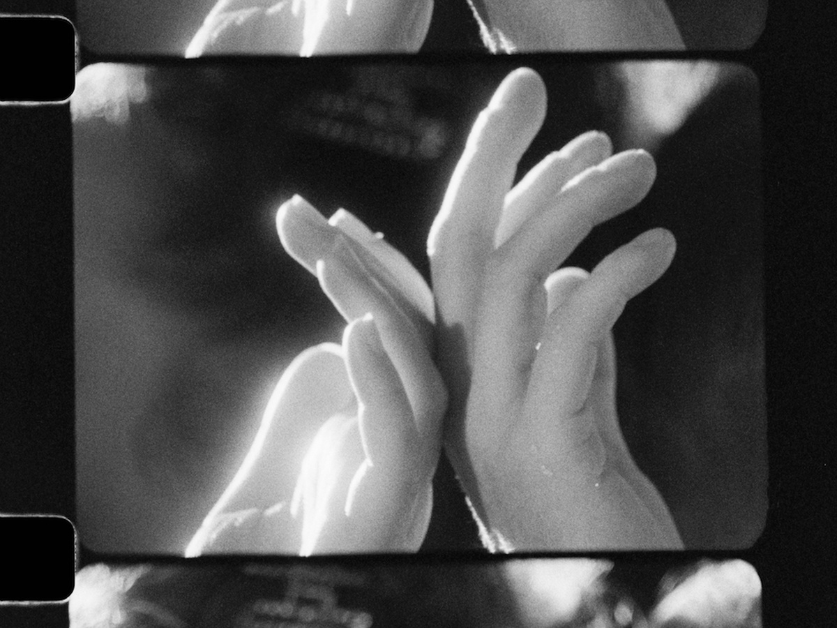 A black and white photo cell, depicting two hands softly facing away from each other.