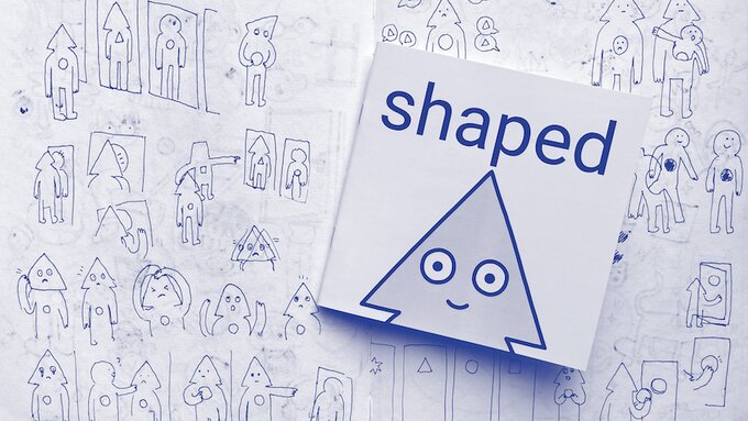 A book titled "Shaped" lays on a page of drawings of a cartoon character with a triangular head.