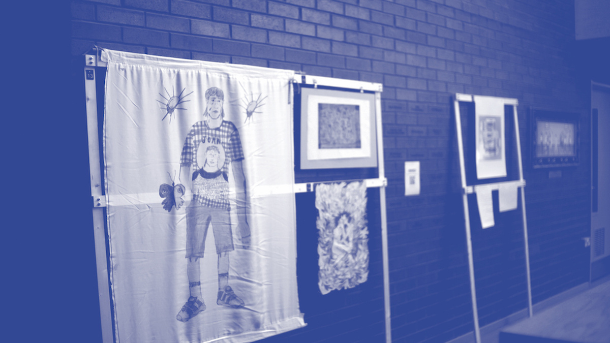 A blue photo of an art installation, a large illustration of someone in shorts is in the foreground.