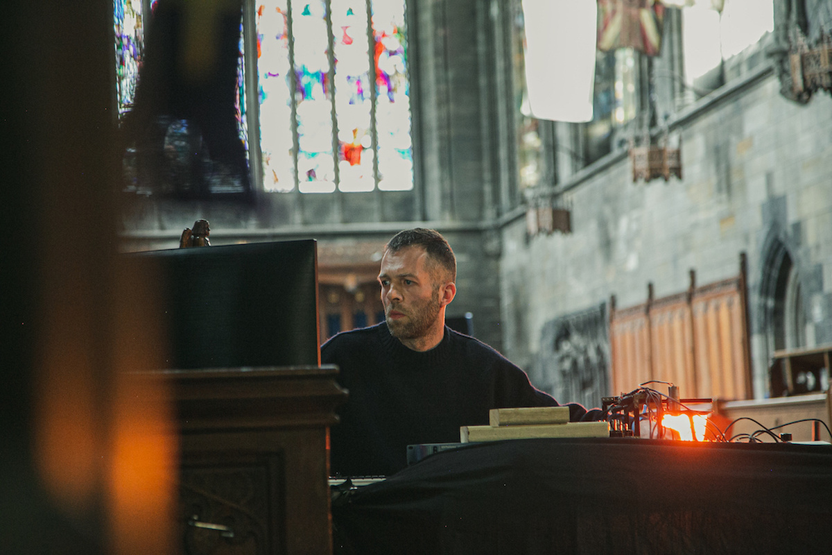 A man sitting down in an abbey performing music