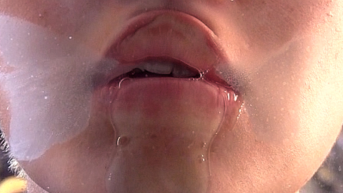 Wet lips pressed against glass.