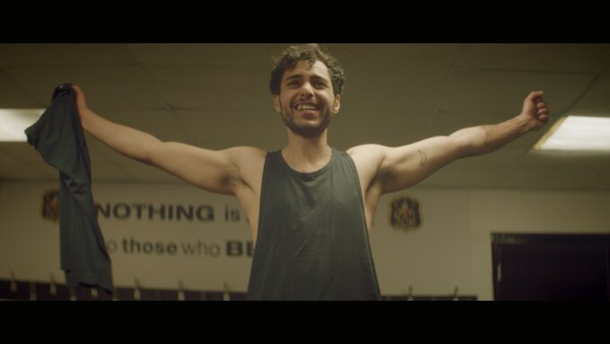 A man smiling with his arms spread wide.