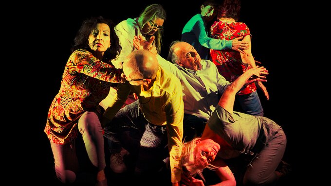 People creating a human ball through movement, bodies moving through each other as the human ball rolls forward.