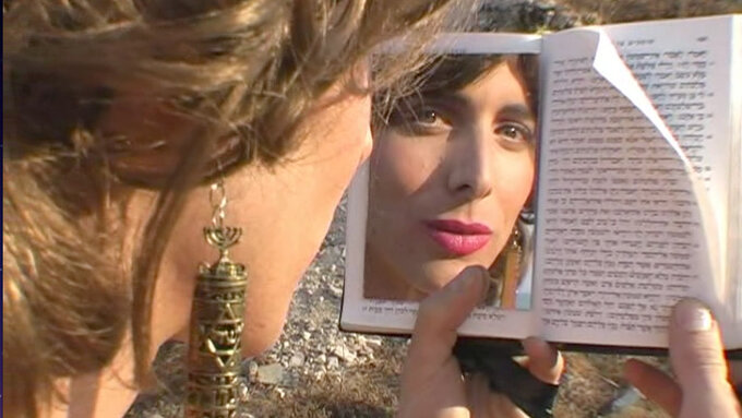 A person looks into a book, one page reflects their face.