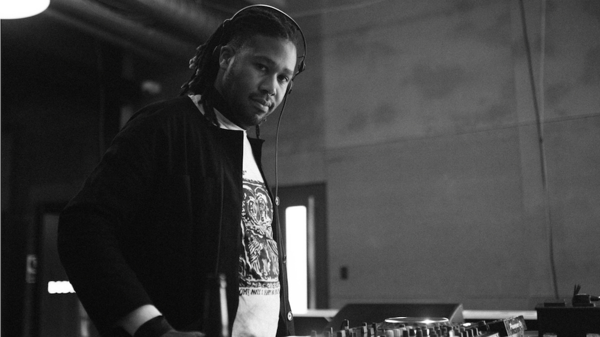 A black and white photograph of a person with dreadlocks wearing headphones.