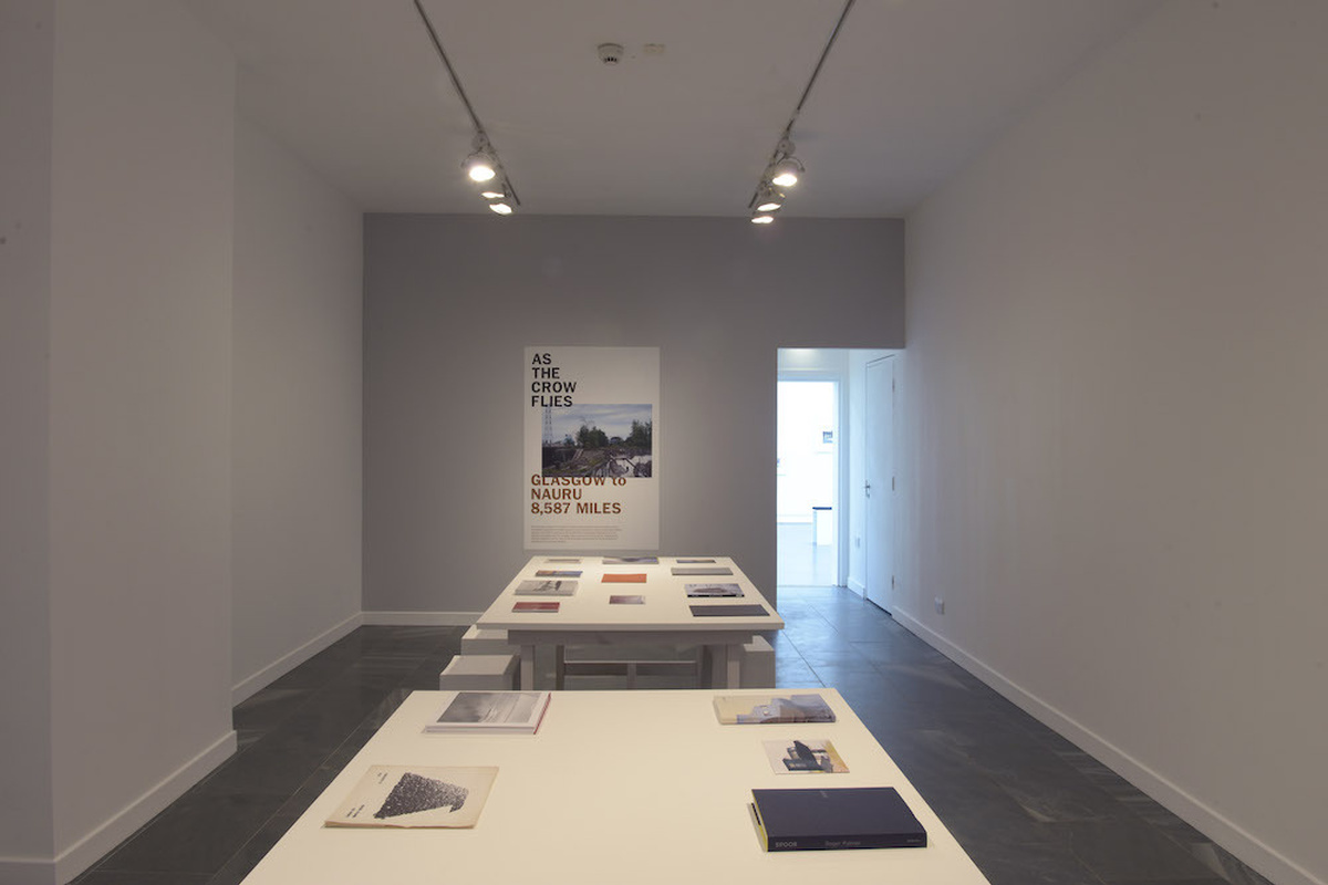 A photo of the reading room with poster in the back wall and books on a desk in the centre.