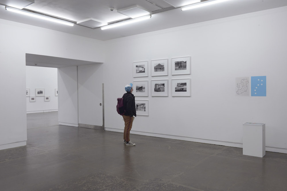 A person looking at an installation of black and white photos