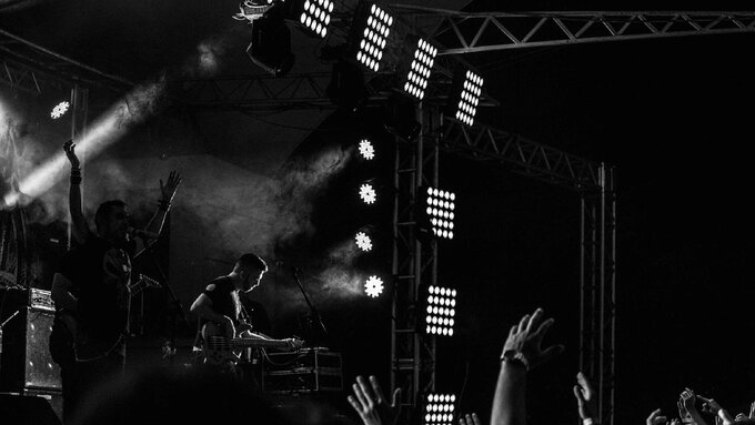 A black and white image of a band playing on stage.