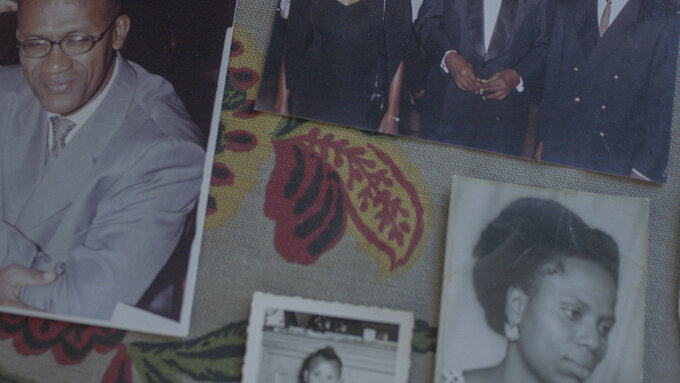 A series of photographs of people are spread out on floral-patterned fabric.