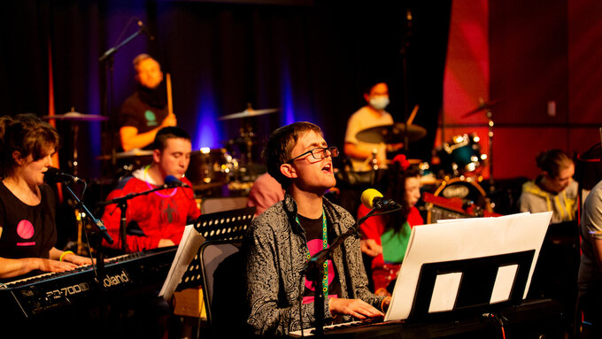 A group of young musicians play several instruments.