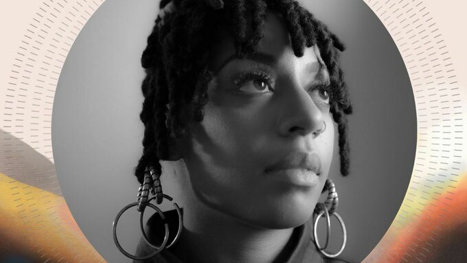 A black and white portrait of Mele Broomes, a black woman with twist braided hair that has gold rings hanging from it.