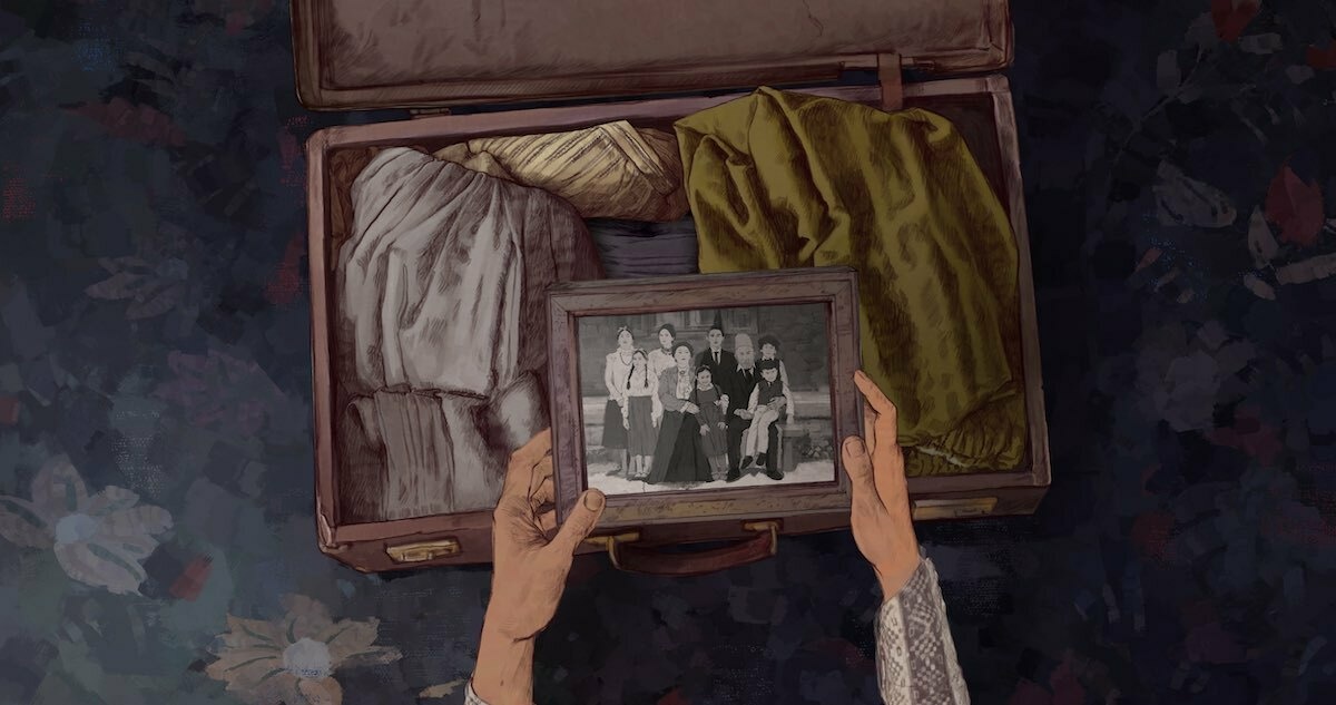 An animated still: two hands holding a black-and-white photograph of a large family above a packed suitcase.