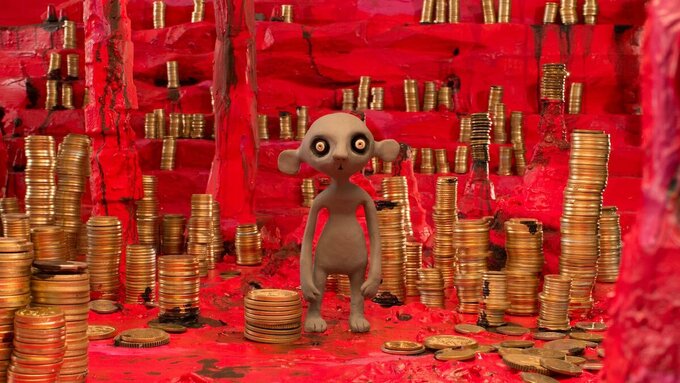 A grey clay mouse with sunken eyes is standing in a red cave, surrounded by stalagmites and stacks of coins.