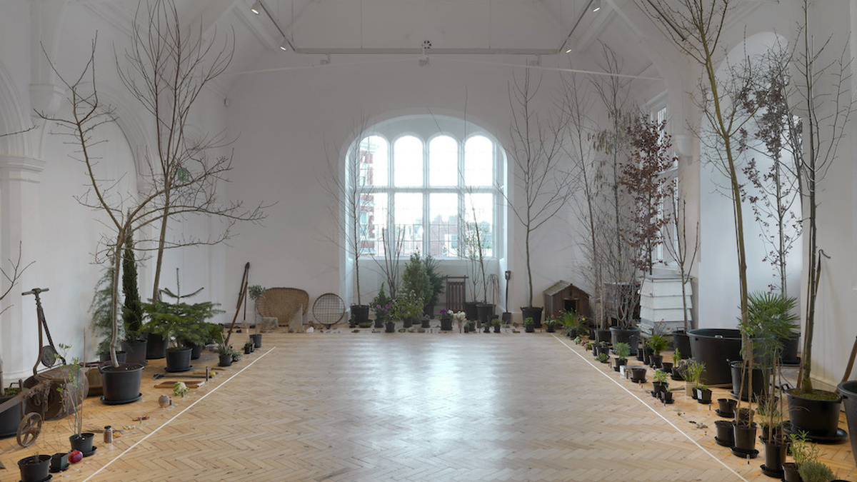 A large well-lit room is covered with potted plants.
