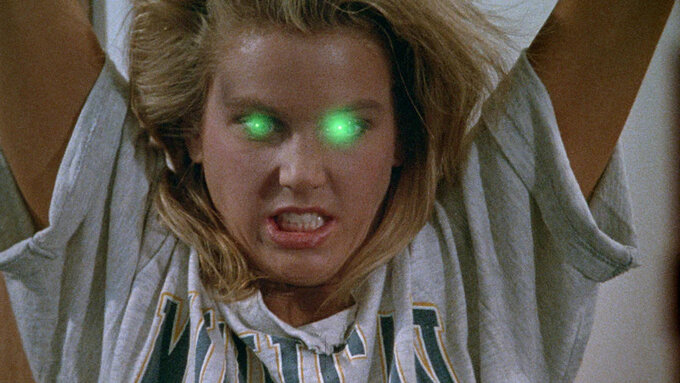 Pictures shows a blonde woman who has been possessed by an alien being. The woman has green, glowing eyes.