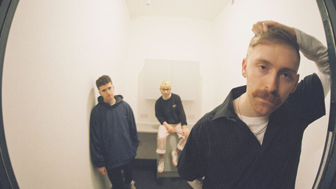 A fish eye lens photograph of three band members.