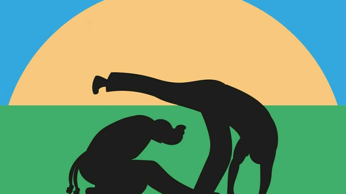 Two silhouettes of people doing capoeira stand on a green plane in front of a yellow sunset.