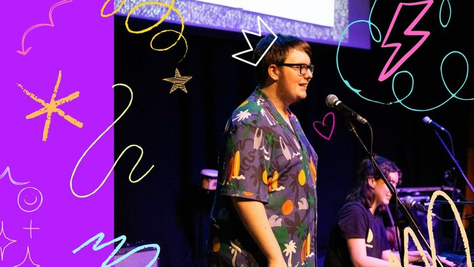 A person in a colourful shirt on stage singing into a microphone, there are bright graphics scribbled across the photo