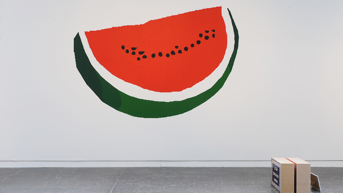 A large painting of a watermelon is displayed on a gallery wall.