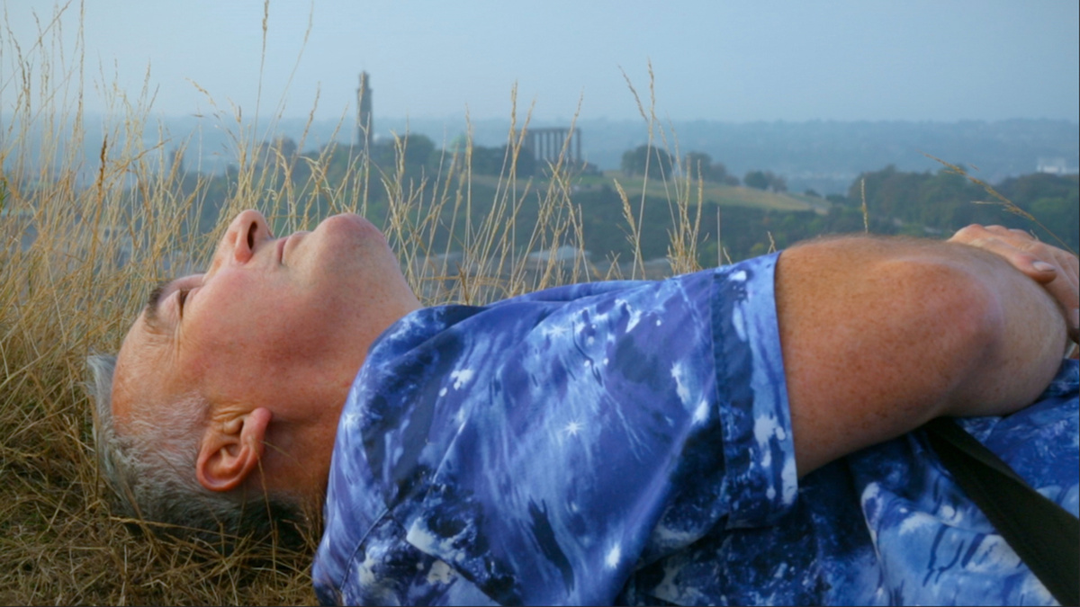 A man lies on his back contemplating the clouds and his hopes for the future.