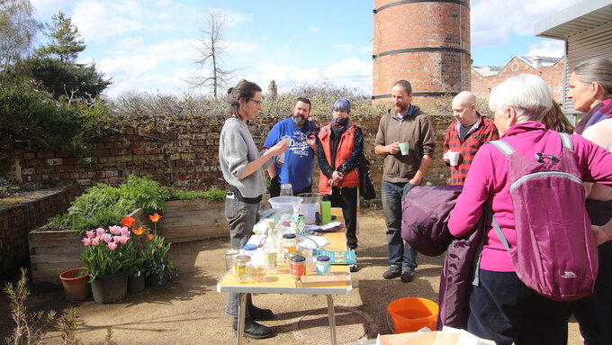 Louise King, speaking to a group of people about seed innoculants, outdoors at The Hidden Gardens