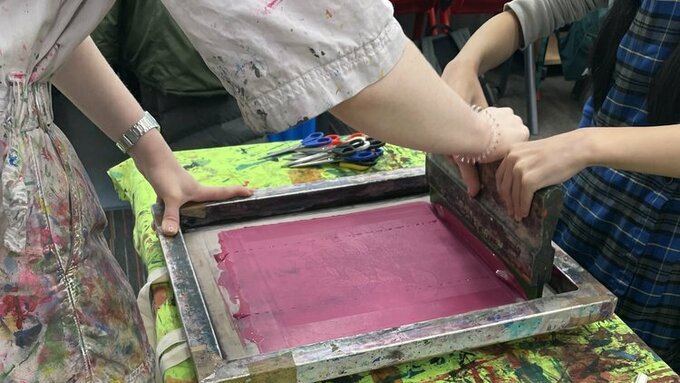 Two people engage with screen printing.