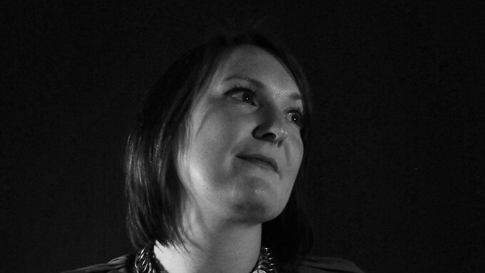 A black and white image of a woman with medium length dark haoir looking away from the camera.