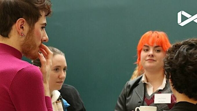 4 gender nonconforming individuals stood in front of a green background.