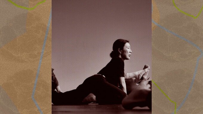 A photo of a woman lifting herself off the floor mid dance move.