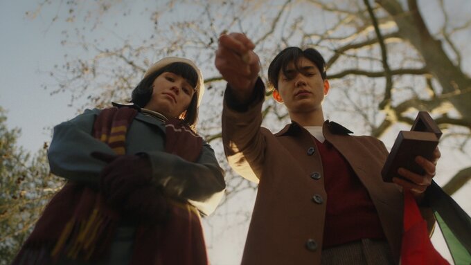 Two people look down towards the camera. As they appear to have dropped something beyond the camera frame.