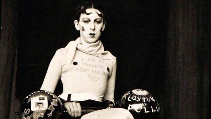 Claude Cahun as weightlifter holding dumb bells