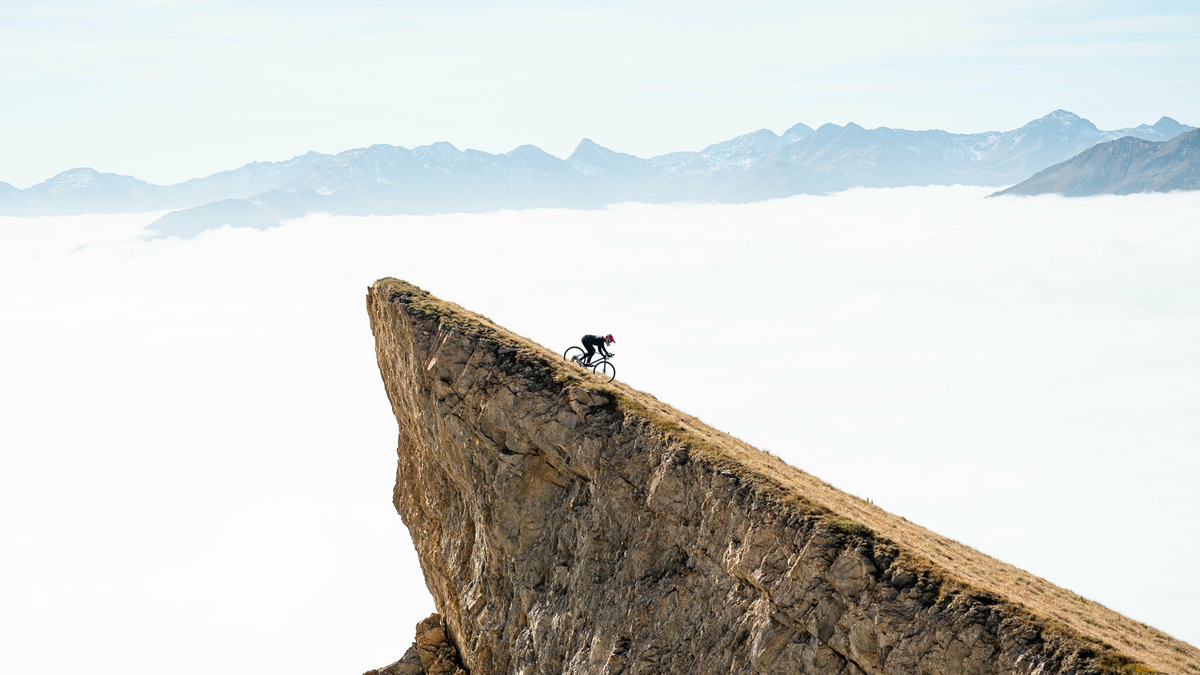A bike riding down a steep and dramatic cliff.