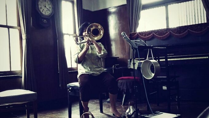 A woman playing the trombone.