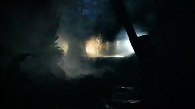 A stream in a landscape lit by glowing lights.