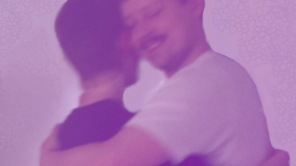 A picture of two people dancing tango together. We can see the face of one of them. Their expression is joyful.