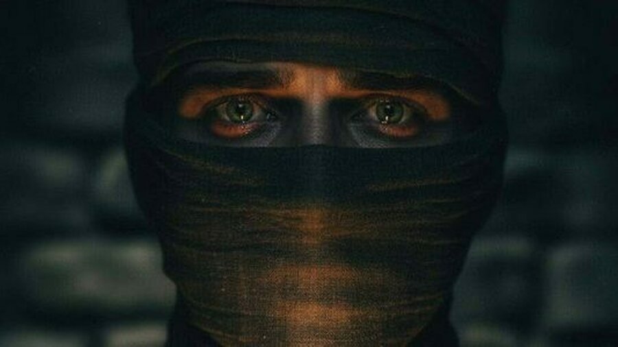 A close up photo of a man wearing a balaclava.
