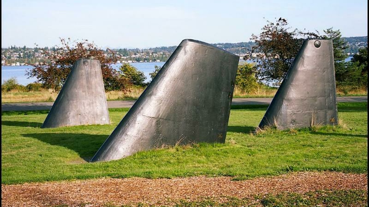 Three metal structures sticking out of a field, they look vaguely militaristic.
