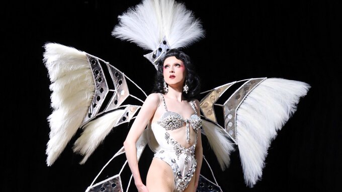 Black background featuring drag artist Marmalade in a showgirl inspired outfit.