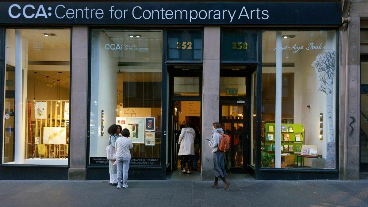 A photograph of the front of CCA with the door open and people entering the building.