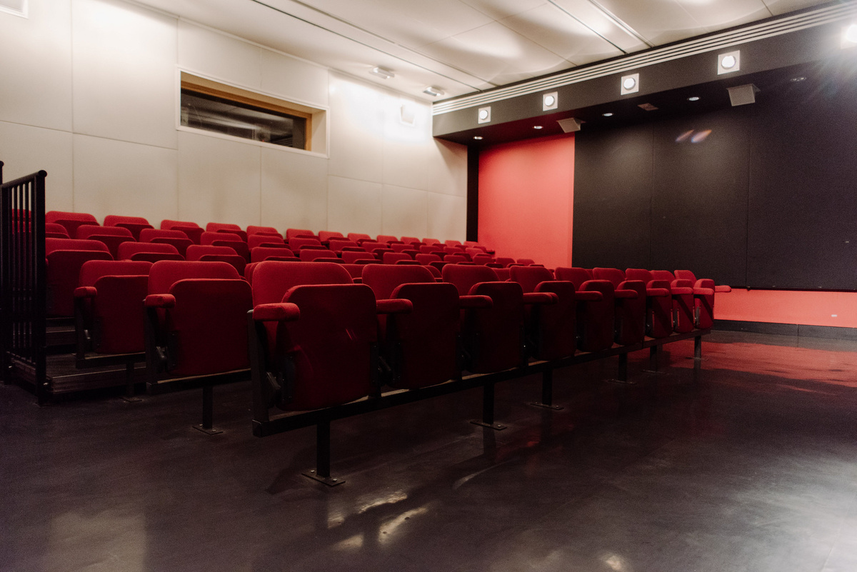 A photograph of the CCA cinema, the seats are red and raked.