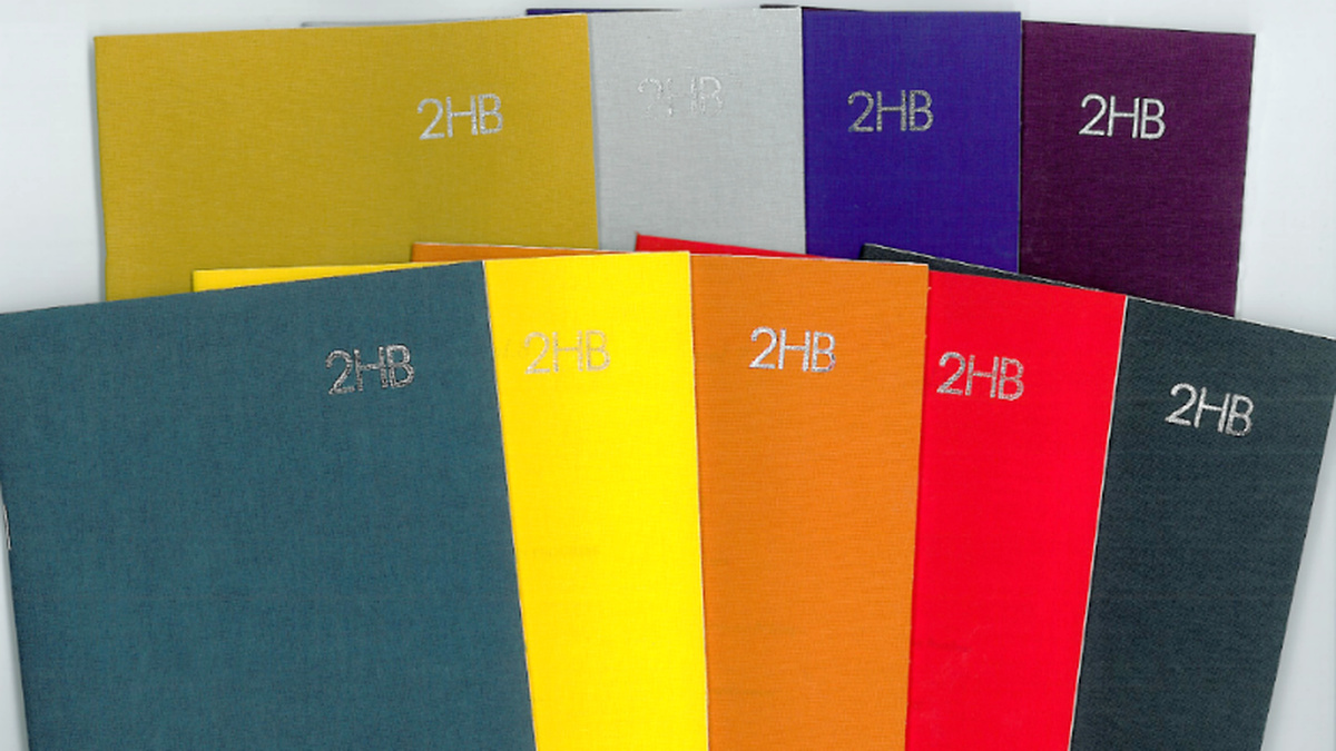 A selection of nine 2HB publications, in a range of bright colours, fanned out.