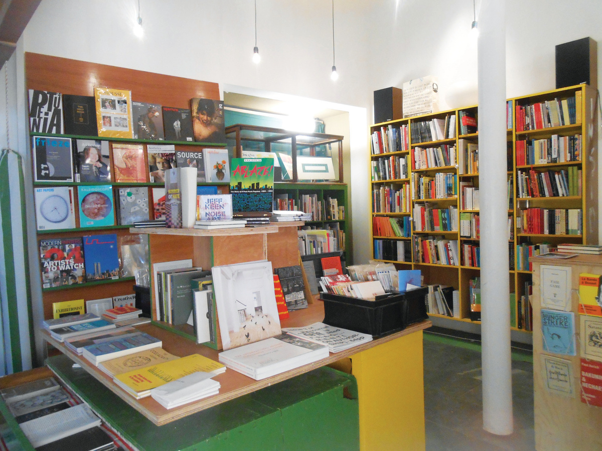 A photograph of Aye-Aye Books, featuring bookshelves and a large display table in the middle of the space.