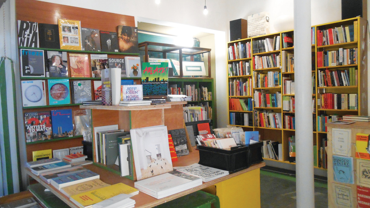 A photograph of Aye-Aye Books, featuring bookshelves and a large display table in the middle of the space.