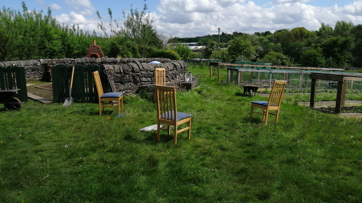 Wooden chairs outside in a sunny green space