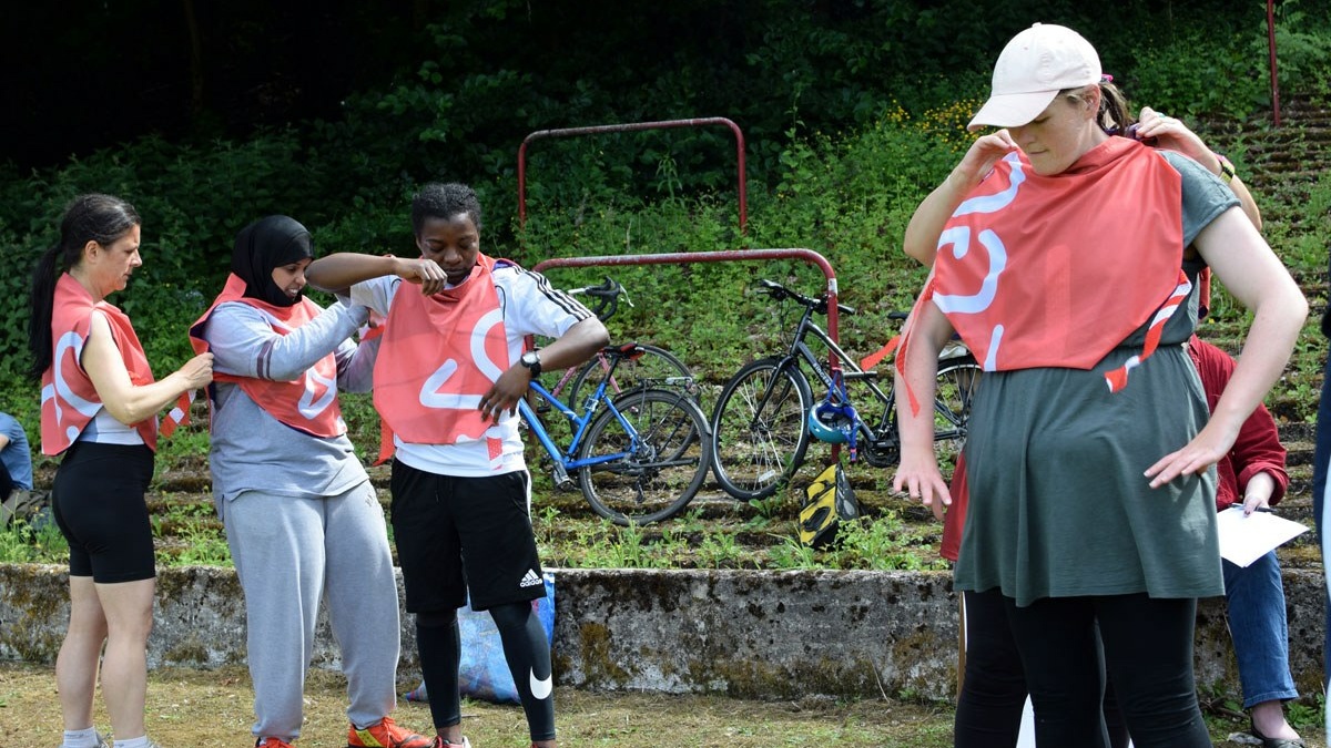 An image of woman and non-binary footballers getting ready to play a cooperative game.