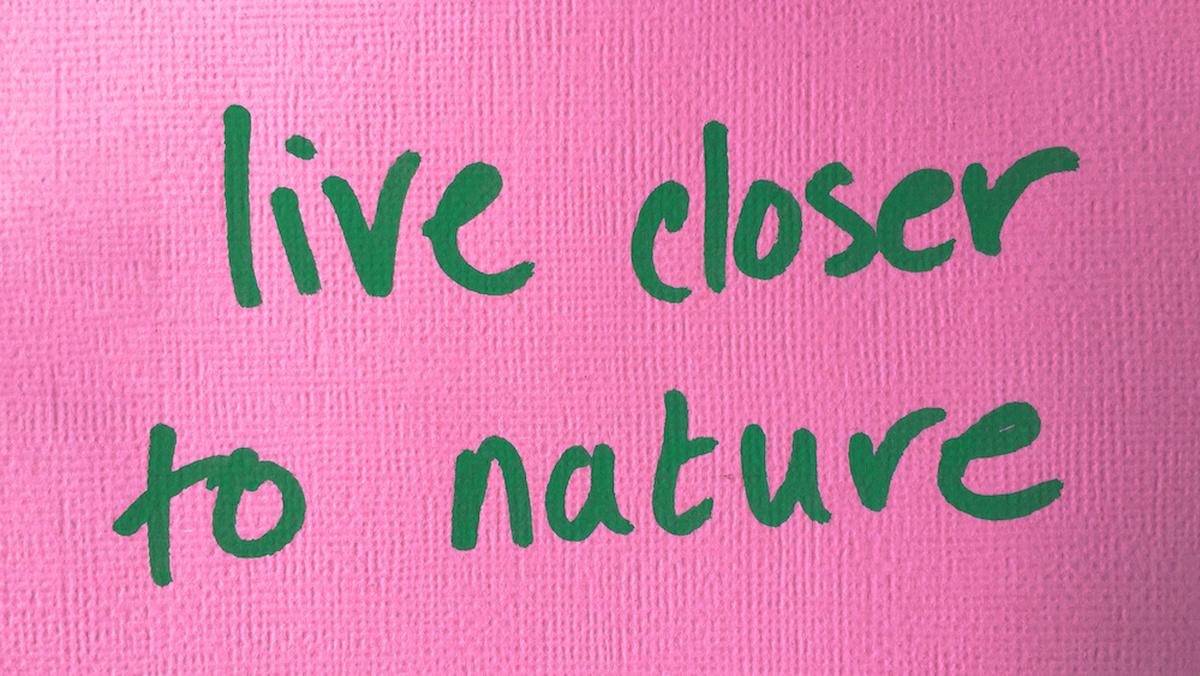 The words 'live closer to nature' are handwritten in green on a textured pink background.