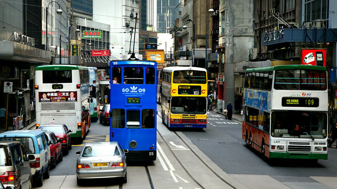Trams and cars driving on the street of Hong Kong.