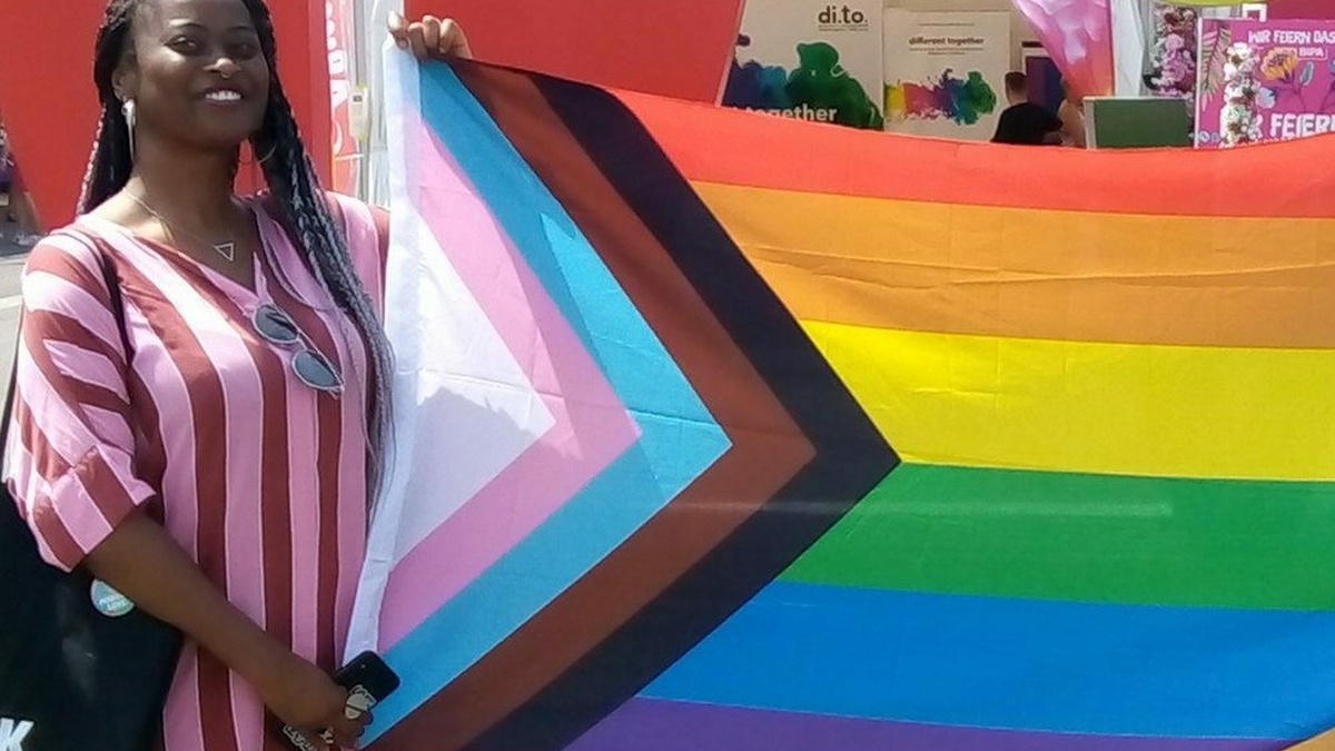 A person holds a progressive pride flag.