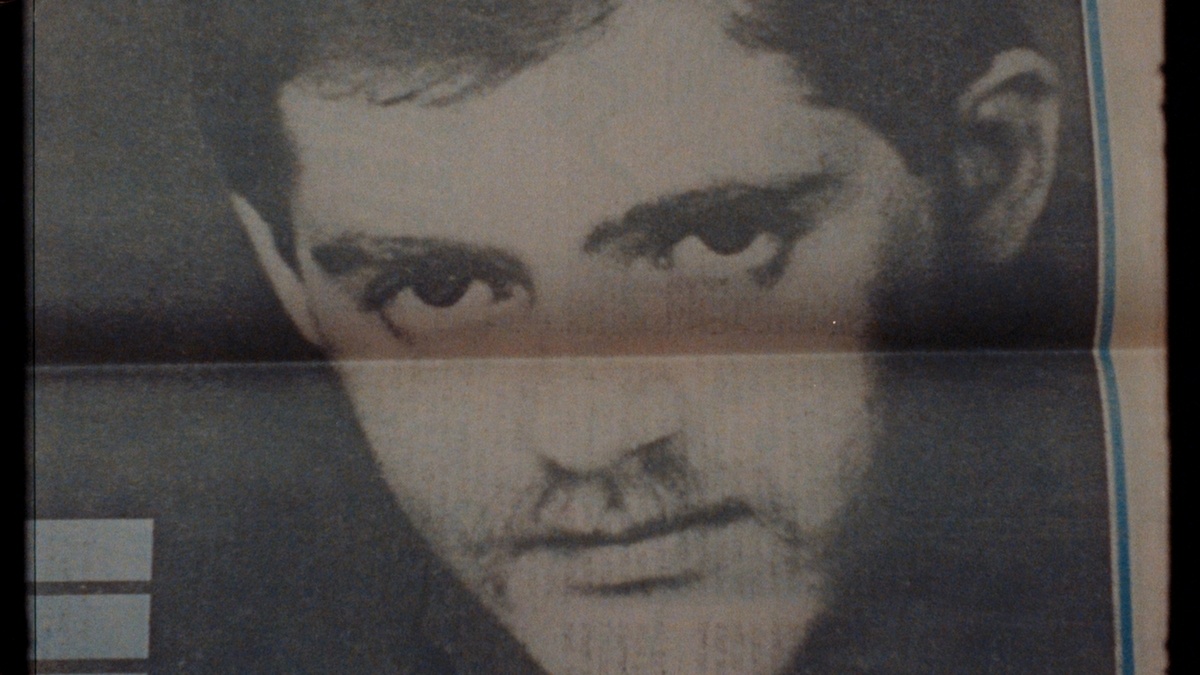 Black and white portrait of Patrick Cowley in a newspaper. A fold in the paper cuts horizontally across Cowley’s face